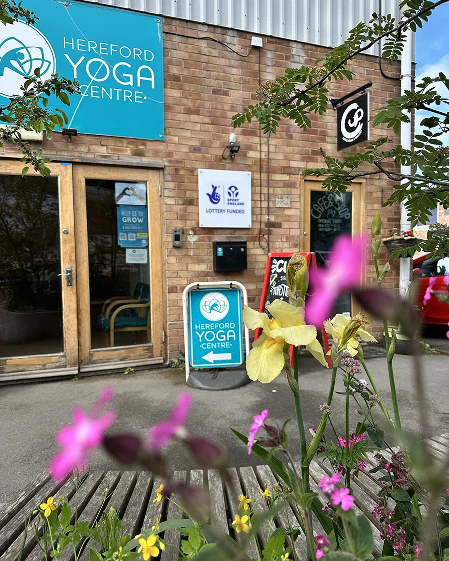 Entrance to Hereford Yoga Centre viewed through flowers in the community garden.